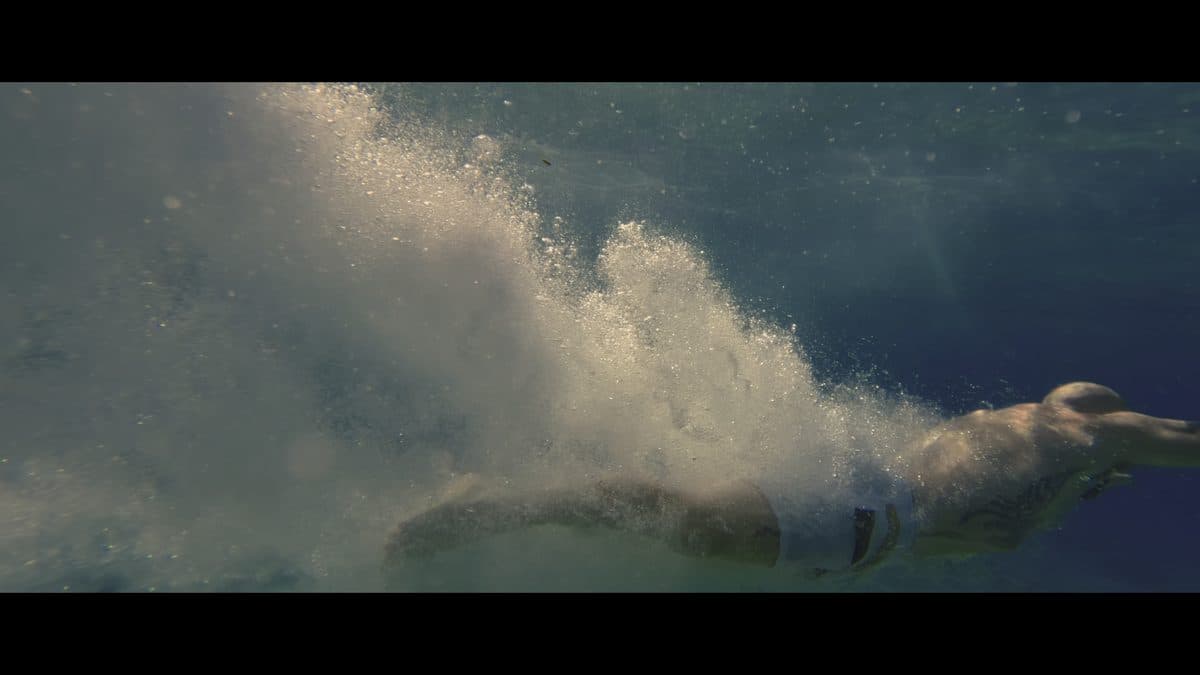 A swimmer underwater in a trail of bubbles